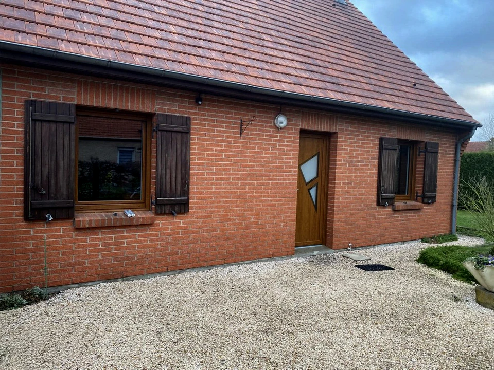 Une personne en tenue de travail blanc effectue des travaux de r&eacute;novation sur une fen&ecirc;tre &agrave; ch&acirc;ssis blanc