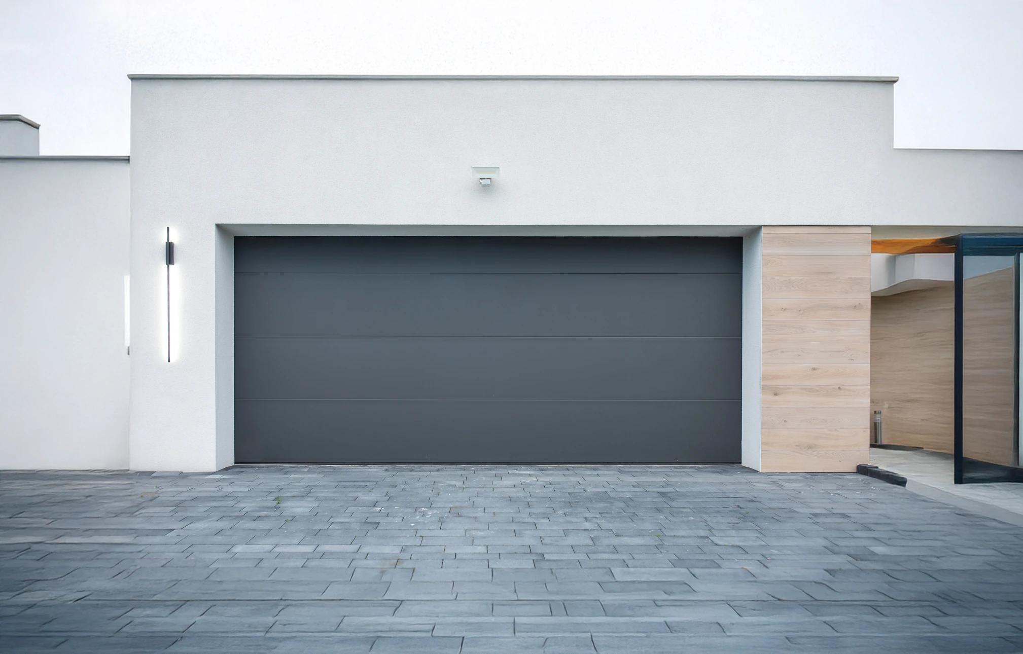 Une main tendue présente des clés de voiture avec télécommande électronique noire à boutons multiples